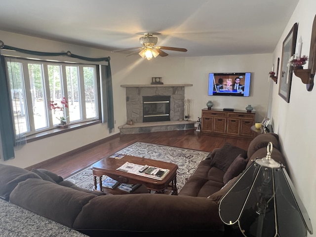 living area featuring a fireplace, wood finished floors, and a ceiling fan