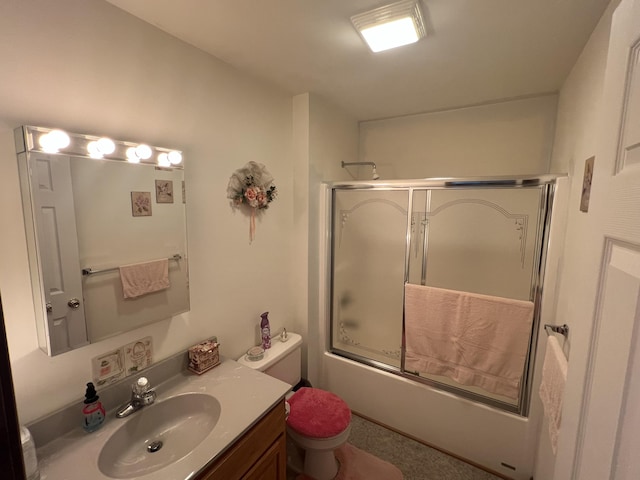 full bathroom with enclosed tub / shower combo, toilet, and vanity