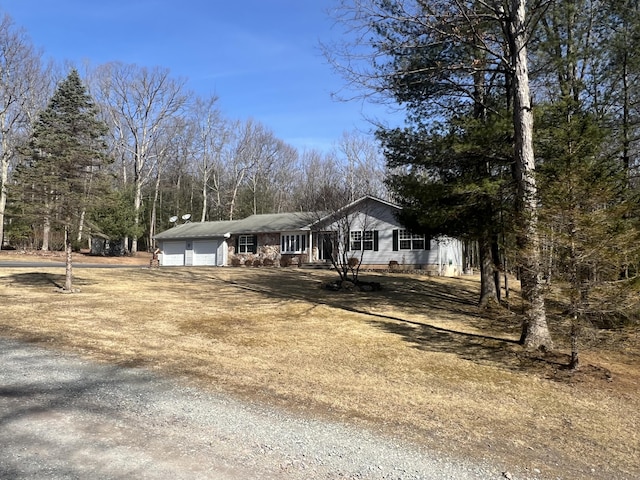 view of front facade featuring a garage and dirt driveway