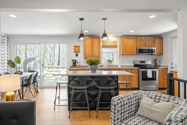 7 Park Ln, Lake Harmony, PA 18624 - kitchen with appliances with stainless steel finishes, a kitchen breakfast bar, a sink, a center island, and light wood-style floors