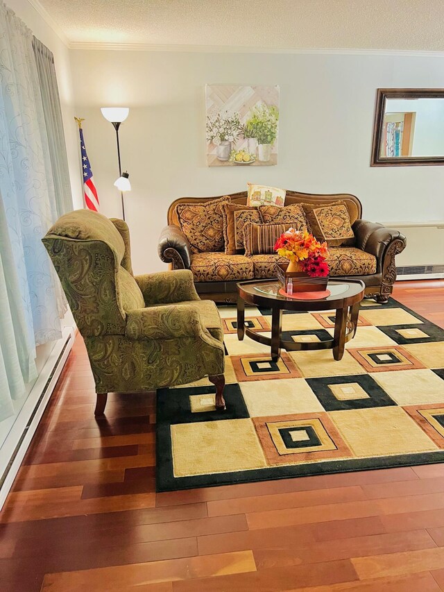 2105 Larkspur Ln, Tobyhanna, PA 18466 - living room featuring wood finished floors, ornamental molding, a baseboard radiator, and a textured ceiling
