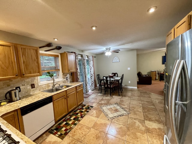 kitchen with tasteful backsplash, a ceiling fan, dishwasher, stainless steel refrigerator with ice dispenser, and a sink