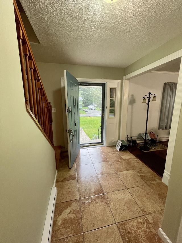 entryway featuring a textured ceiling, stairway, and baseboard heating