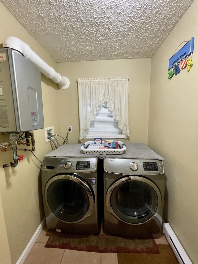 clothes washing area with a textured ceiling, a baseboard radiator, laundry area, separate washer and dryer, and water heater