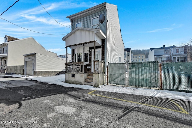 view of front of house featuring a porch, fence, and a gate