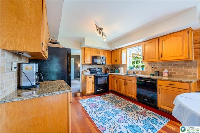 5622 Snowdrift Rd, Orefield, PA 18069 - kitchen with black appliances, wood finished floors, tasteful backsplash, light stone counters, and brown cabinetry