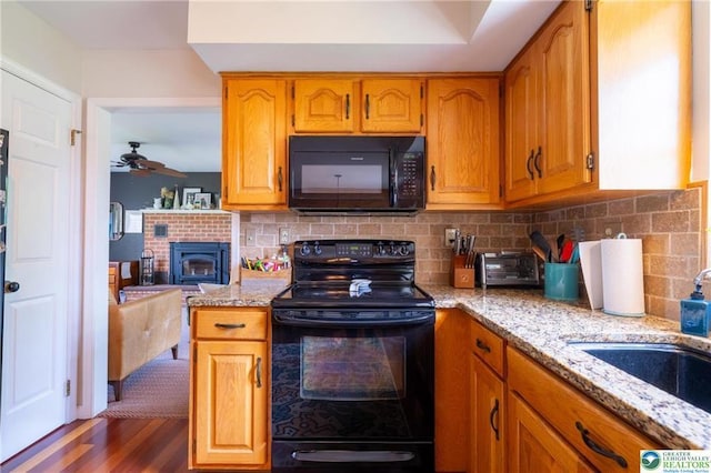 5622 Snowdrift Rd, Orefield, PA 18069 - kitchen with black appliances, light stone countertops, a ceiling fan, and decorative backsplash