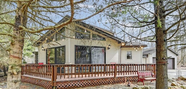 back of property with a wooden deck, a garage, and an outdoor structure