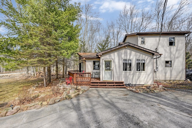 rear view of property featuring a wooden deck