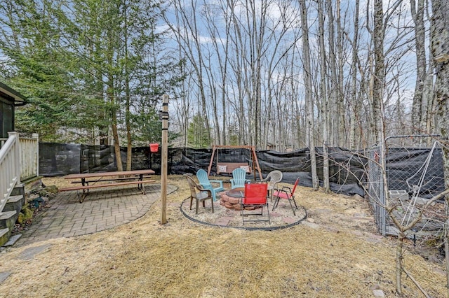 view of yard featuring an outdoor fire pit, a patio, and fence