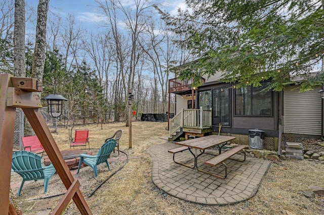 view of yard featuring a playground, a patio area, a sunroom, and a fire pit