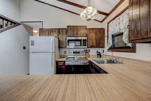 kitchen with vaulted ceiling with beams, a sink, light countertops, appliances with stainless steel finishes, and a chandelier