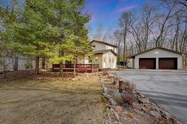 view of side of home with an outbuilding, a deck, and a garage