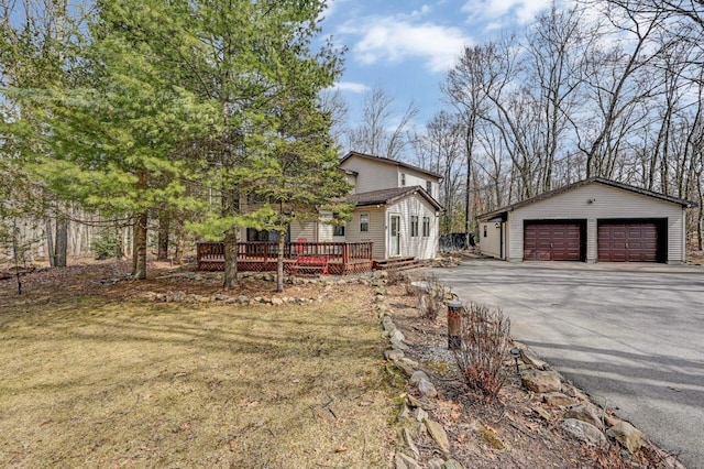 exterior space with an outbuilding, a garage, and a wooden deck