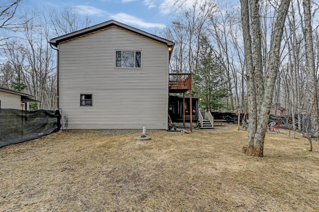 back of property featuring a deck and fence