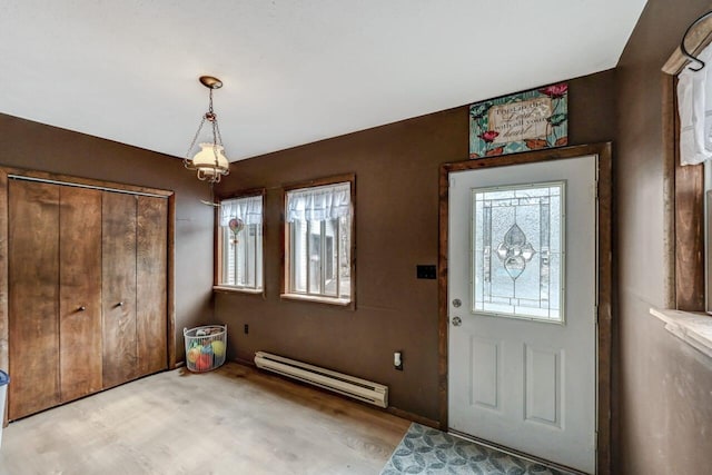 entrance foyer with light wood finished floors and a baseboard radiator