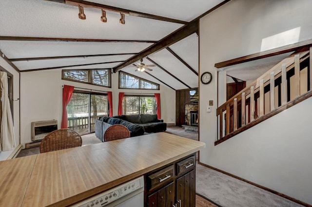 kitchen featuring heating unit, a ceiling fan, a fireplace, wood counters, and light carpet