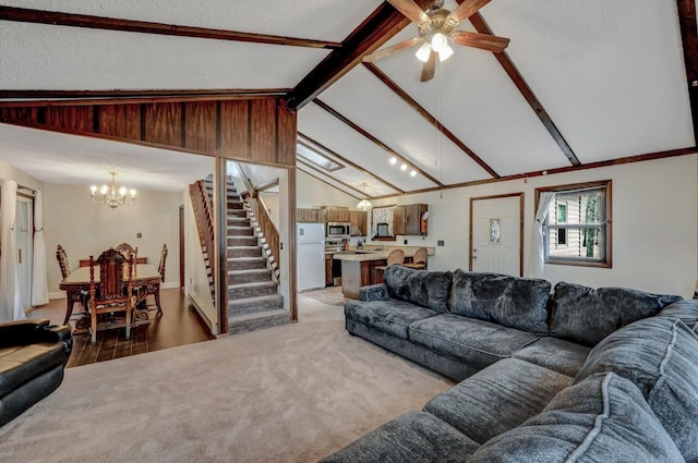 living room with light carpet, stairway, ceiling fan with notable chandelier, and lofted ceiling with beams