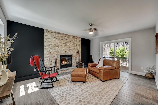 348 Mountain Top Lake Rd, Long Pond, PA 18334 - living room featuring ceiling fan, wood finished floors, a stone fireplace, and baseboards