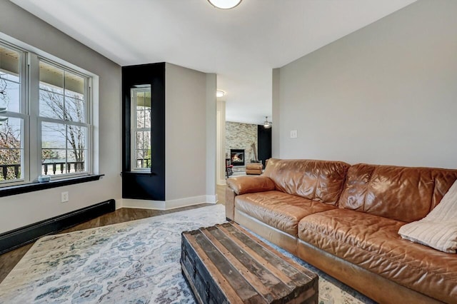 348 Mountain Top Lake Rd, Long Pond, PA 18334 - living area featuring dark wood-style floors, a glass covered fireplace, and baseboards