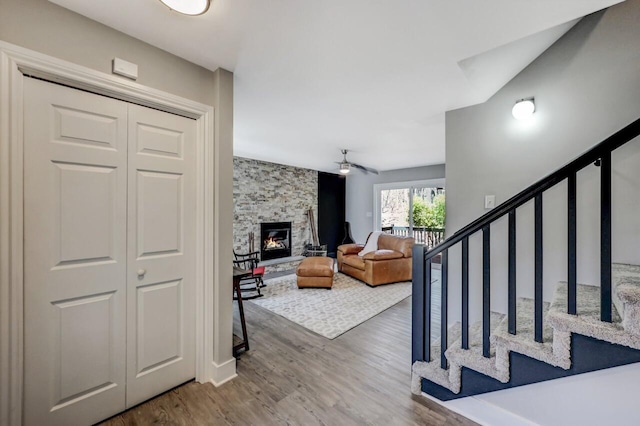 348 Mountain Top Lake Rd, Long Pond, PA 18334 - living area featuring wood finished floors, a stone fireplace, a ceiling fan, and stairway