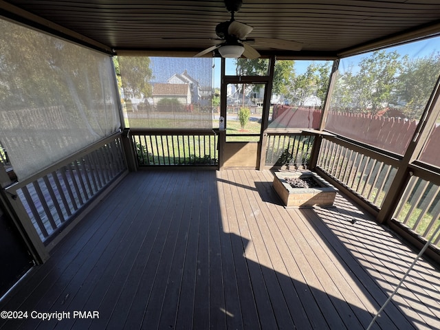 wooden terrace with a fire pit and a ceiling fan