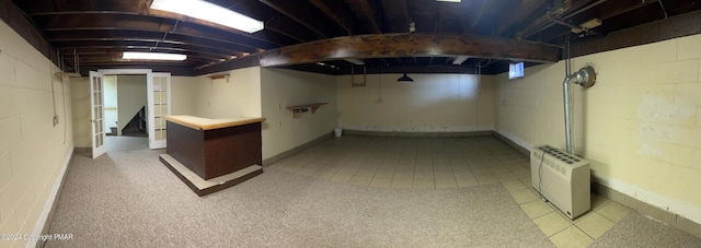 finished basement with tile patterned flooring and concrete block wall