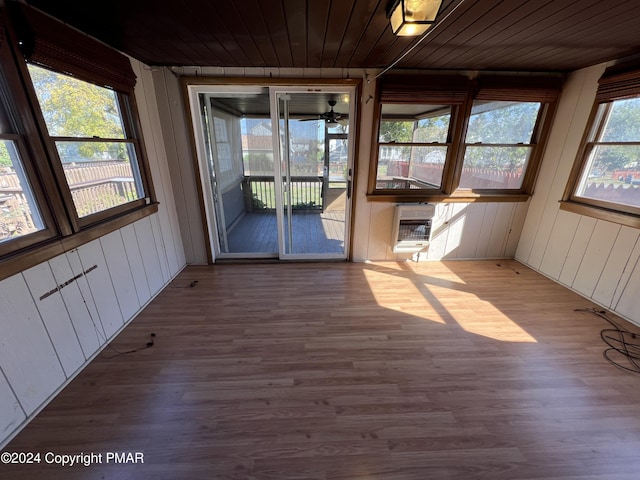 unfurnished sunroom featuring wood ceiling and heating unit