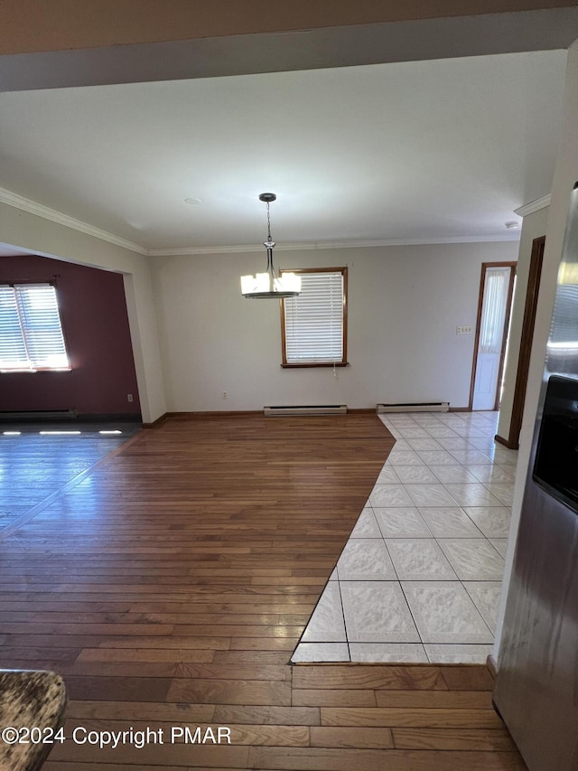 interior space with ornamental molding, a notable chandelier, baseboards, and wood finished floors