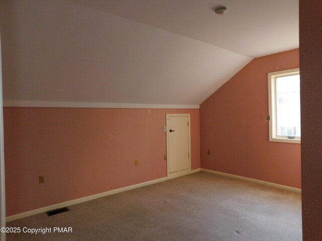 bonus room with lofted ceiling, visible vents, light carpet, and baseboards