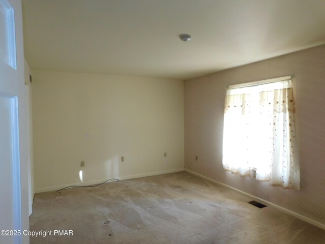 spare room with baseboards, visible vents, and carpet flooring