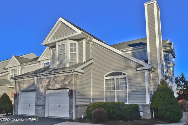 127 Bethpage Ter, Easton, PA 18042 - view of side of home with a chimney, driveway, and a garage
