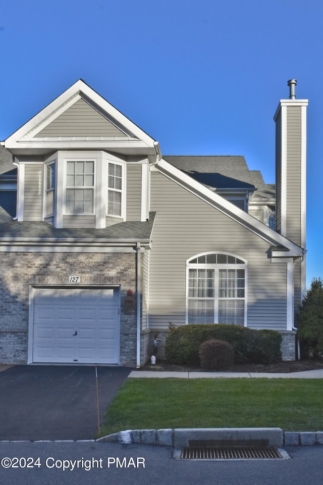 127 Bethpage Ter, Easton, PA 18042 - view of front facade featuring driveway, a front yard, an attached garage, and a chimney