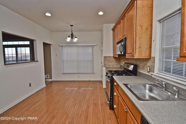 127 Bethpage Ter, Easton, PA 18042 - kitchen with stainless steel range with gas cooktop, black microwave, a chandelier, brown cabinets, and light wood-style floors