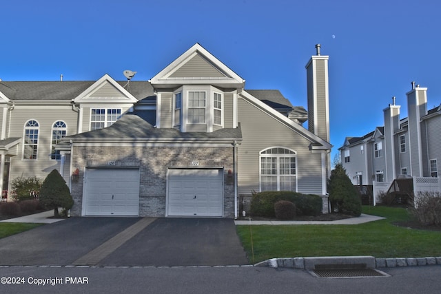 127 Bethpage Ter, Easton, PA 18042 - traditional-style home with asphalt driveway, a front lawn, a garage, and a chimney