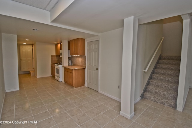 127 Bethpage Ter, Easton, PA 18042 - kitchen with light countertops, light tile patterned floors, white appliances, decorative backsplash, and brown cabinetry