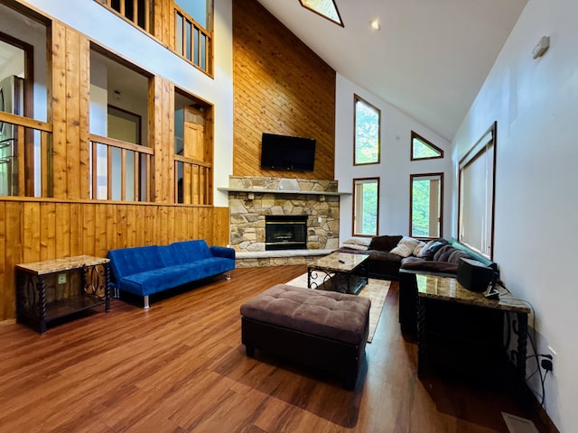 119 Sterling Cir, Bushkill, PA 18324 - living area featuring high vaulted ceiling, wood finished floors, a stone fireplace, and wooden walls