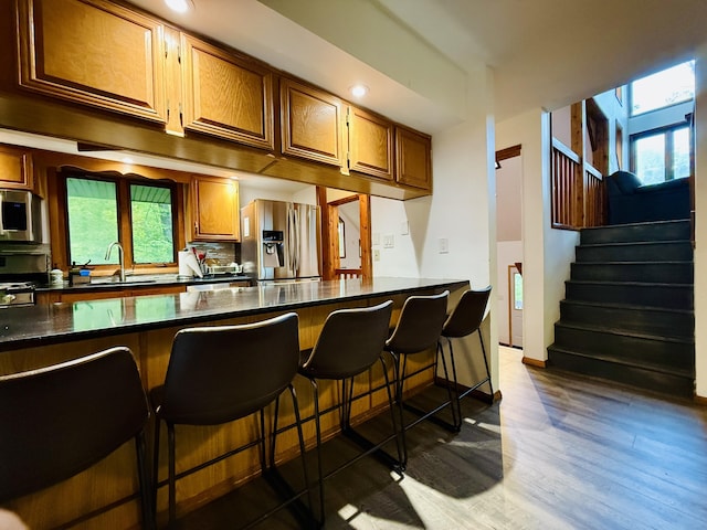 119 Sterling Cir, Bushkill, PA 18324 - kitchen with stainless steel appliances, a breakfast bar area, dark wood-type flooring, brown cabinetry, and recessed lighting