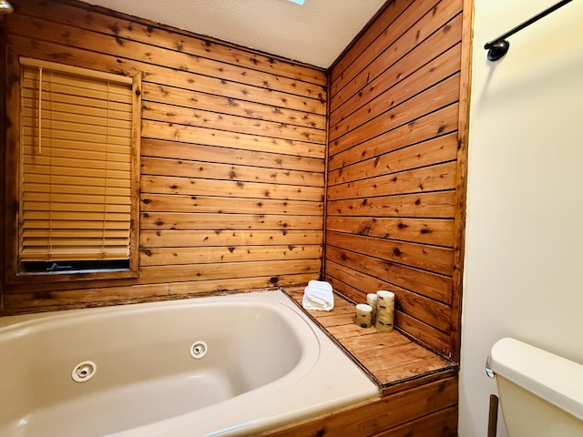 119 Sterling Cir, Bushkill, PA 18324 - bathroom featuring wooden walls, a whirlpool tub, and a textured ceiling