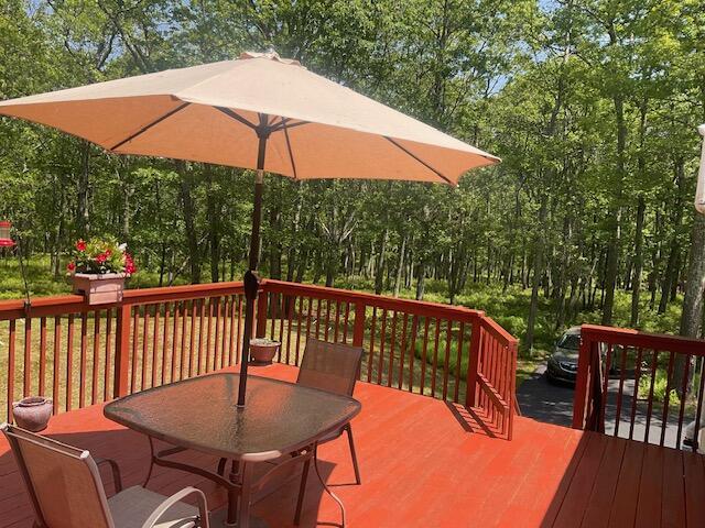 3124 Bluebird Dr, Bushkill, PA 18324 - wooden deck featuring outdoor dining area and view of wooded area