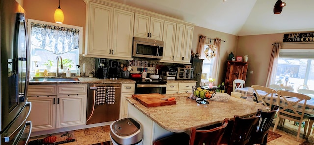 149 Oak, Cresco, PA 18326 - kitchen featuring appliances with stainless steel finishes, cream cabinetry, lofted ceiling, a breakfast bar area, and light stone countertops