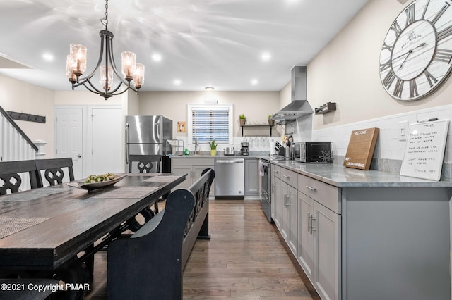 11 Middle Village Way, Tannersville, PA 18372 - kitchen featuring dark wood-type flooring, hanging light fixtures, gray cabinets, stainless steel appliances, and wall chimney range hood