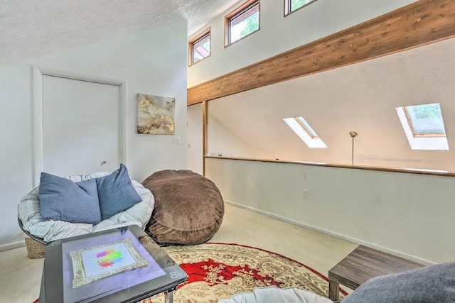 348 Fernwood Dr, East Stroudsburg, PA 18301 - living area with a skylight, vaulted ceiling, carpet flooring, and a textured ceiling
