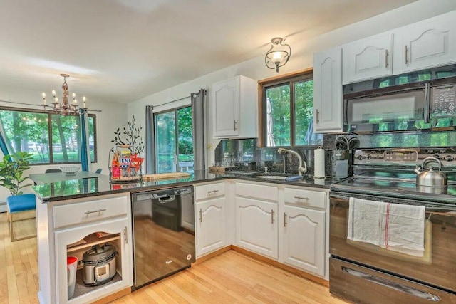 348 Fernwood Dr, East Stroudsburg, PA 18301 - kitchen with black appliances, a peninsula, a chandelier, white cabinetry, and plenty of natural light