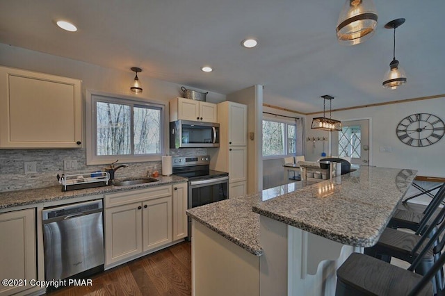 36 Maplewood Rd, Lake Harmony, PA 18624 - kitchen with stainless steel appliances, a sink, dark wood finished floors, backsplash, and a breakfast bar area