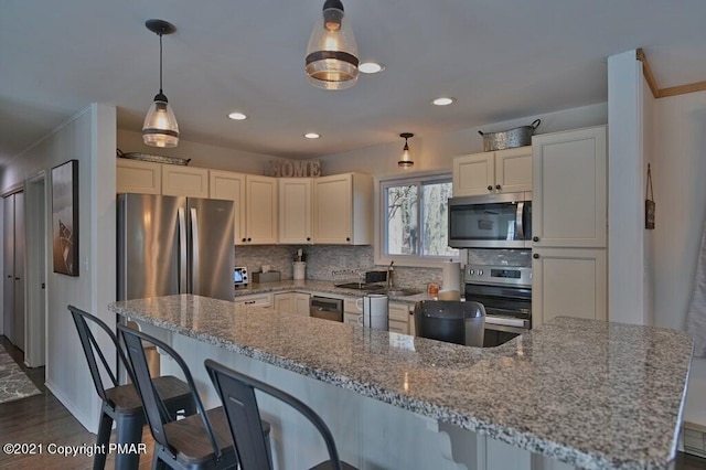 36 Maplewood Rd, Lake Harmony, PA 18624 - kitchen with stainless steel appliances, decorative backsplash, a breakfast bar, light stone countertops, and recessed lighting