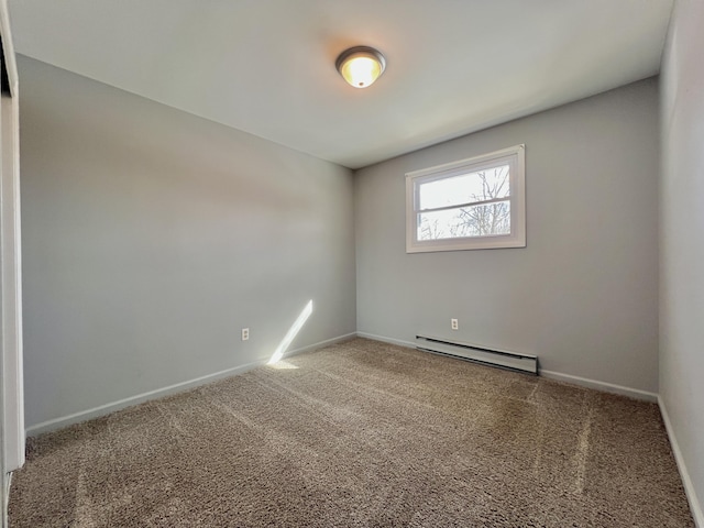empty room with a baseboard heating unit, carpet floors, and baseboards
