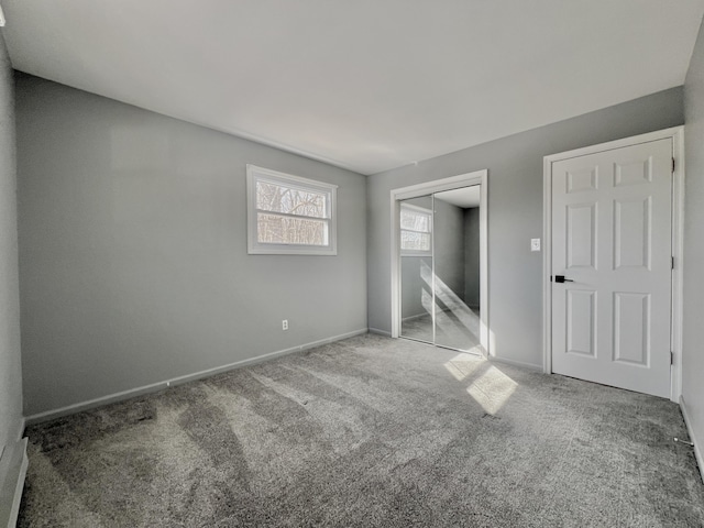 unfurnished bedroom with carpet flooring, a closet, and baseboards