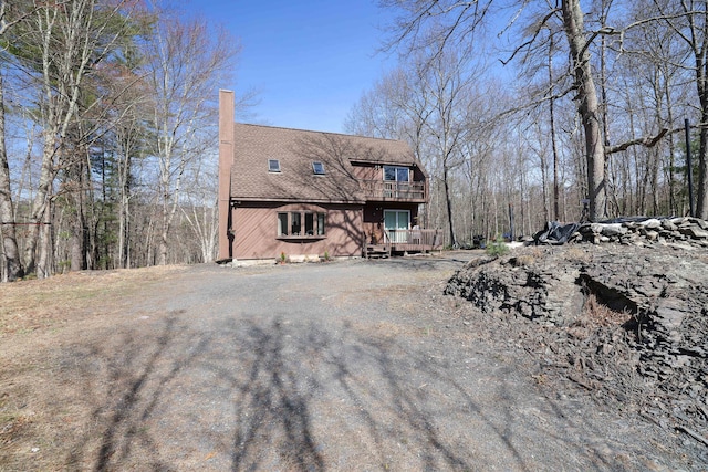 1239 Mink Trl, Bushkill, PA 18324 - view of front of property featuring driveway, a shingled roof, a chimney, and a balcony