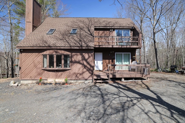 1239 Mink Trl, Bushkill, PA 18324 - view of front of property with a shingled roof, a chimney, and a balcony